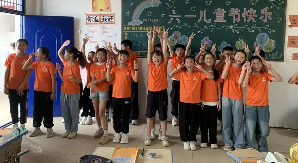 Students in orange Larkspur Project shirts in a classroom