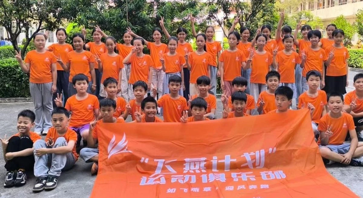 A school group photographed with a Larkspur Project banner