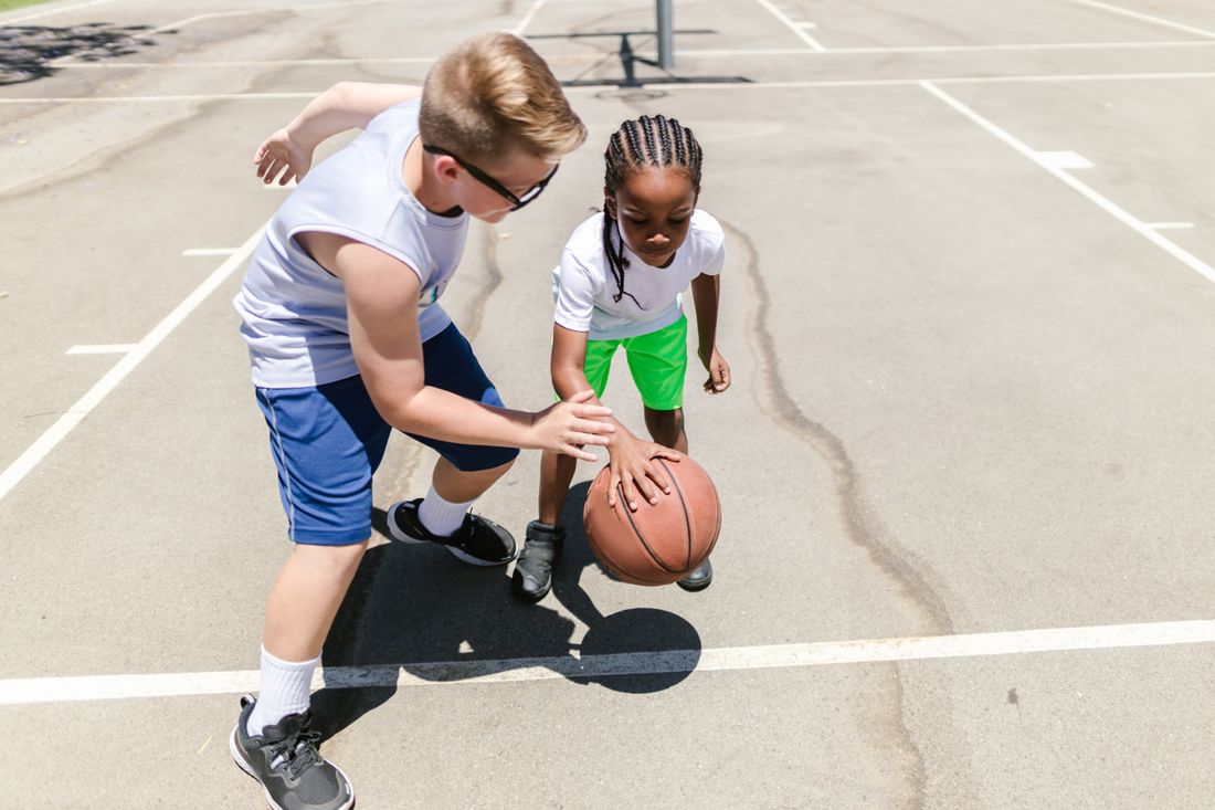 Children practicing basketball together